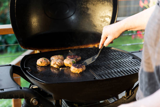 Man Flipping Burger On Home Barbecue Setup Man flipping burger on home barbecue setup. griddle stock pictures, royalty-free photos & images