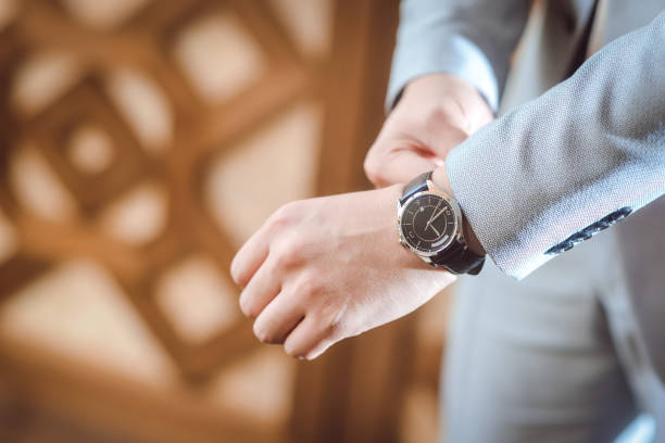 istock Well Dressed Man putting his wrist watch 1128666193