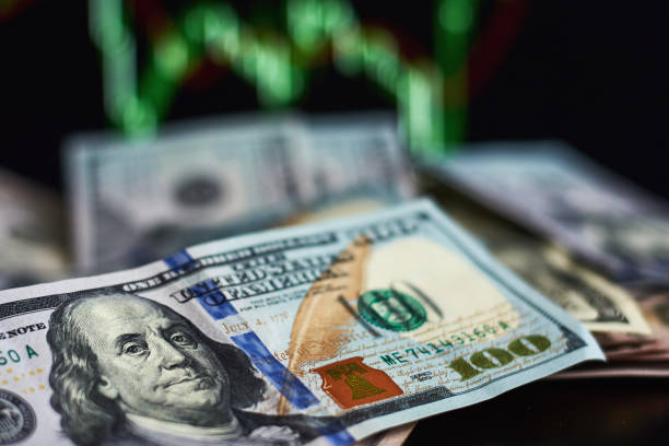 istock US dollar bills on a background with dynamics of exchange rates. Trading and financial risk concept 1128668513