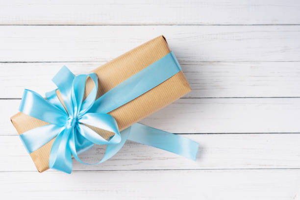 istock gift box with blue bow on a white wooden background with copy space 1128668545
