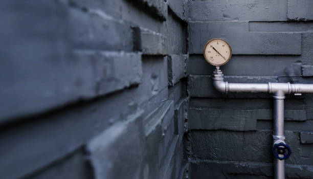 istock Water Pressure Gauge Meter on Pipes at Outside Building. Grey Brick Wall as background 1128668727