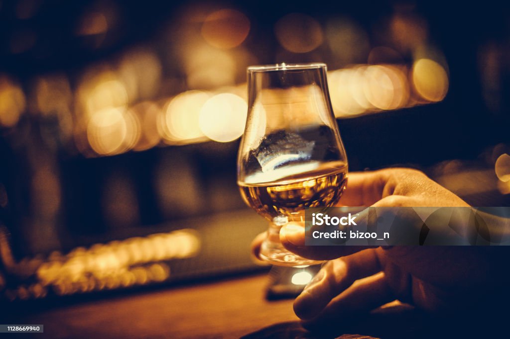 Main retenant un verre de whisky de single malt de Glencairn - Photo de Whisky libre de droits