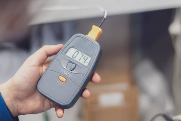 istock worker in blue uniform hold electric miltimeter to check voltage b 1128670038