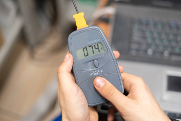 istock worker in blue uniform hold electric miltimeter to check voltage b 1128670050