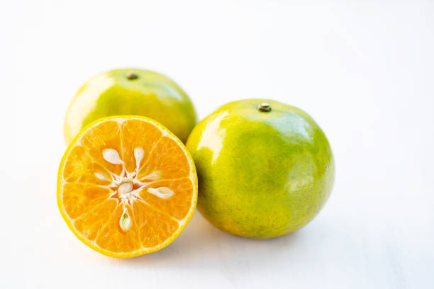 Green tangerine orange fruit on white table, healthy fruit