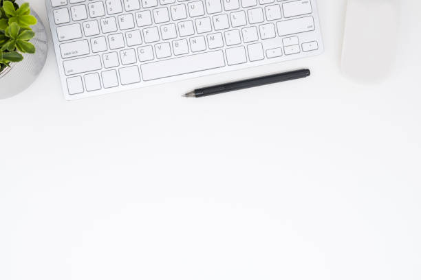 istock White office desk table with computer gadgets and pen. Top view with copy space, flat lay. 1128670994