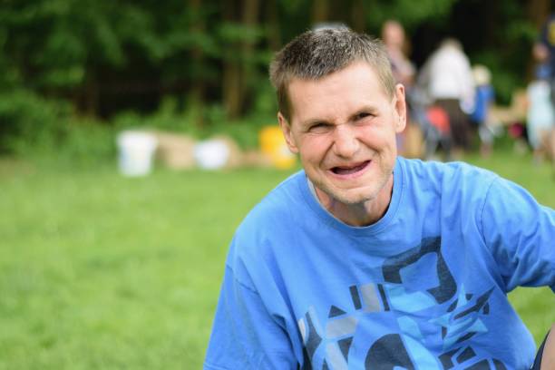 Portrait of happy smiling handicaped man. Rybna nad Zdobnici, Czech Republic, 12.5.2018, Day Of Smiles, beneficent charity happening for handicapped children. Portrait of happy smiling handicaped man. developmental disability stock pictures, royalty-free photos & images