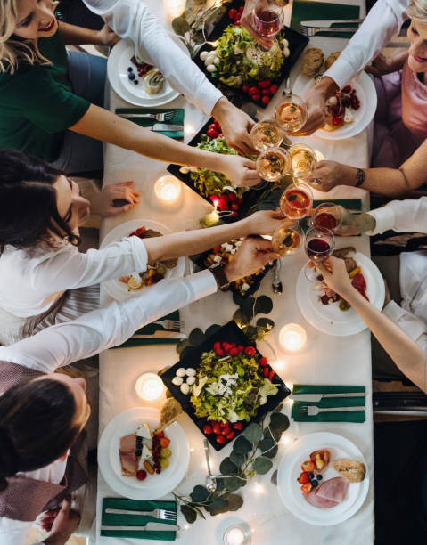 a midsection people sitting at a table on a indoor party, clinking glasses. top view. - eating people group of people home interior imagens e fotografias de stock