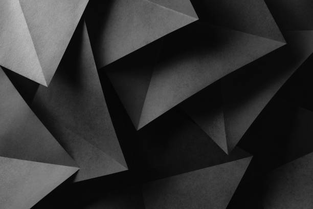 istock Triangular shapes of gray paper for dark astract background 1128673233