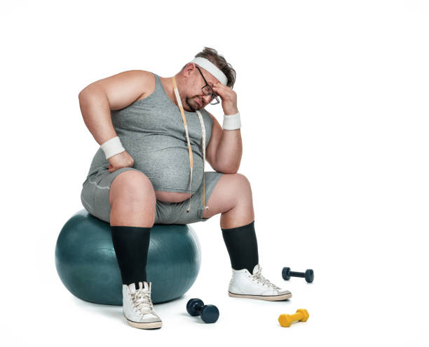 engraçado desportista com excesso de peso, sentado sobre a bola de fitness - overweight dieting men unhealthy eating - fotografias e filmes do acervo