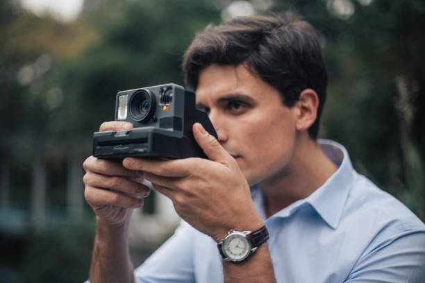 istock Male photographer photographing with old camera 1128675411