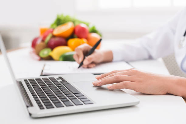 istock Nutritionist doctor writing diet plan on table 1128676608