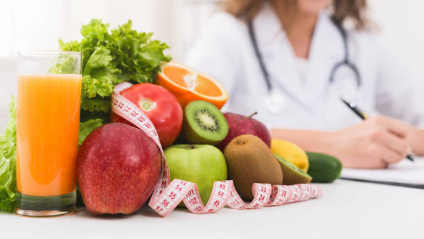 istock Female nutritionist doctor writing vegetable diet plan 1128676611