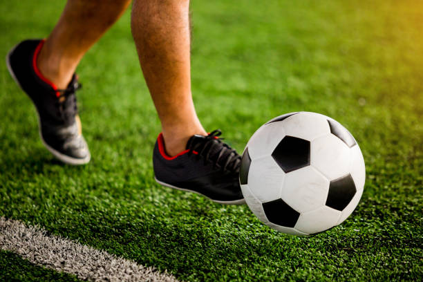 istock Soccer player speed run to shoot ball to goal on artificial turf 1128677555