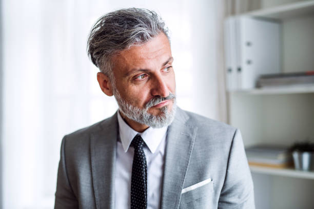 istock A serious mature businessman standing in an office. 1128678880