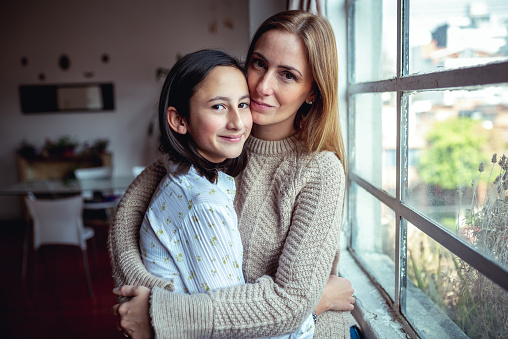 Lovely mother and daughter looking at camera