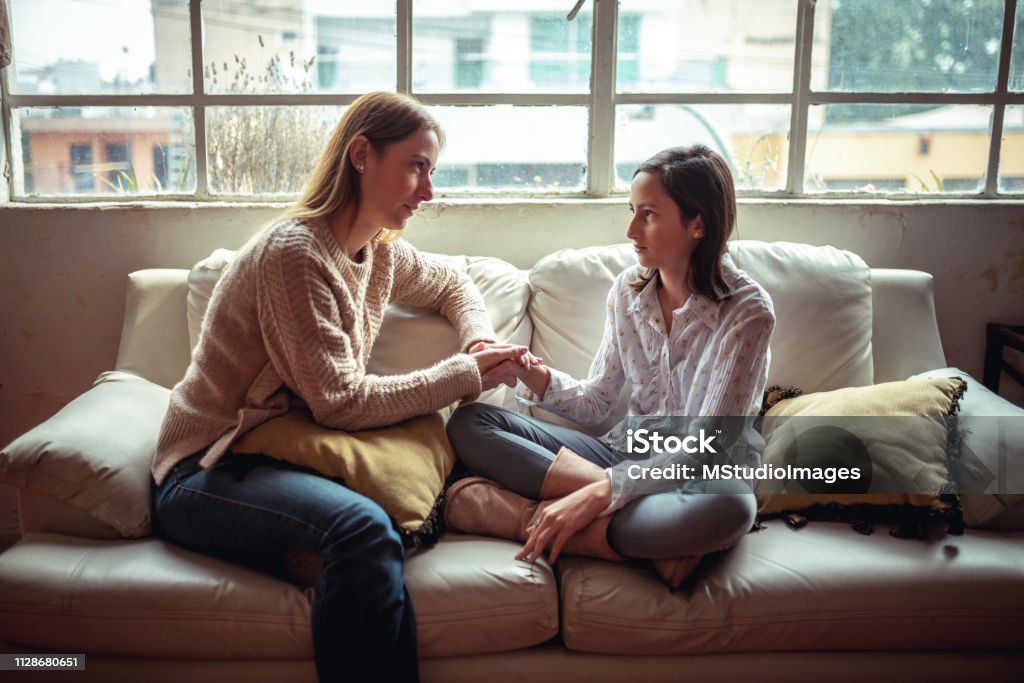 Mother and daughter having a talk. Mother and daughter at home having a serious talk. Parent Stock Photo