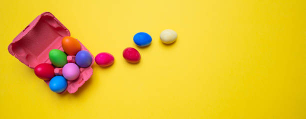 istock Easter eggs, pastel colors painted and a carton case, yellow background, banner 1128681229