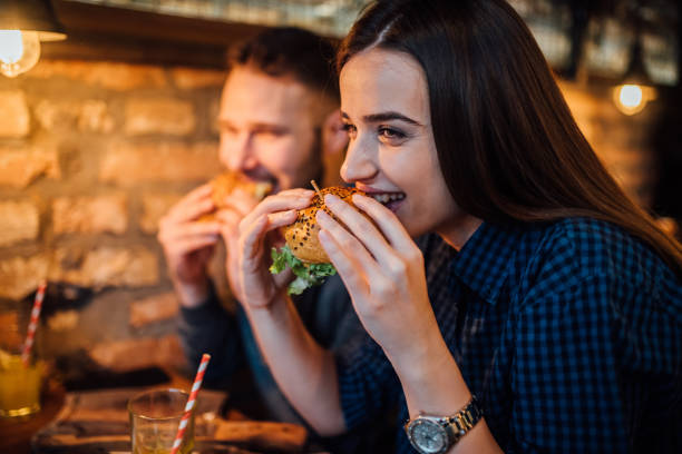 istock Couple eating hamburgers 1128681752