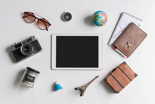Empty screen tablet with travel accessories and items on white background with copy space, Travel concept
