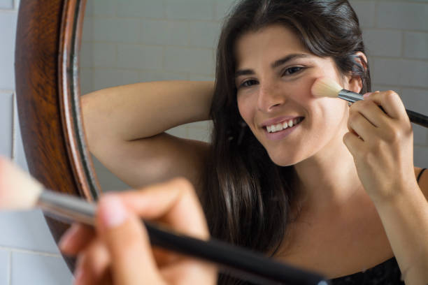 istock Woman applying make up in bathroom. 1128682994