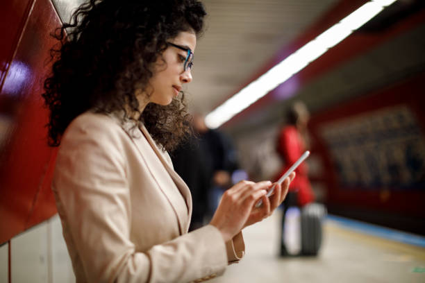 istock Young businesswoman using mobile phone on the subway station 1128683402