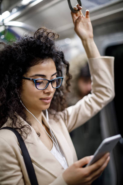 istock Young woman using smartphone in public transport 1128683432
