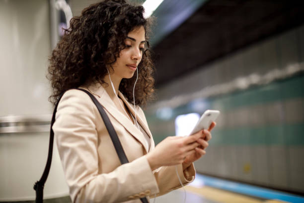 Young woman using smartphone at subway station