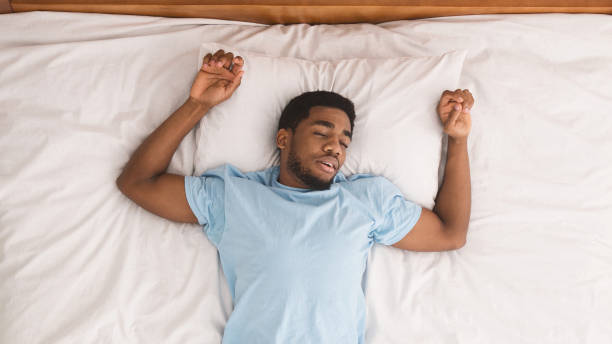 istock Young african-american man sleeping in bed top view 1128684596