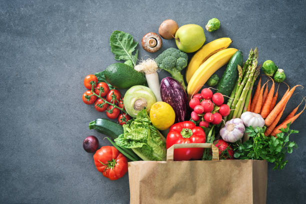 bolsa llena de frutas y verduras frescas - frescura fotografías e imágenes de stock