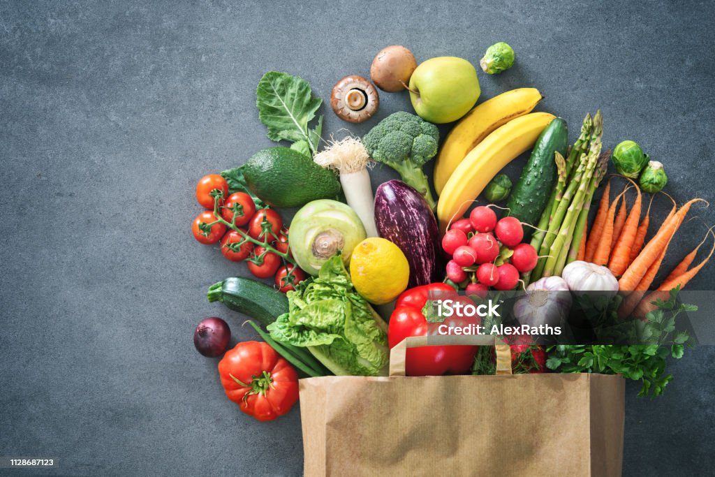 Shopping bag full of fresh vegetables and fruits Healthy food selection. Shopping bag full of fresh vegetables and fruits. Flat lay food on table Vegetable Stock Photo