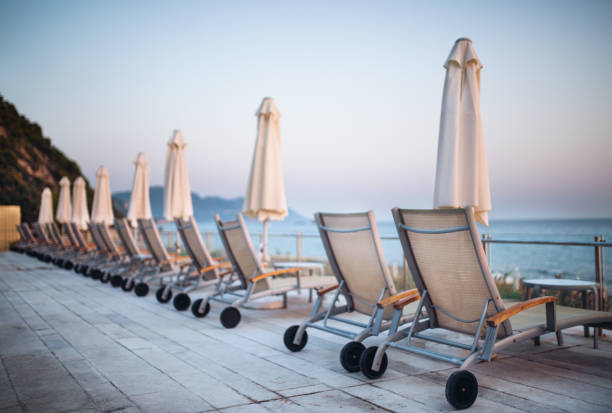istock Beach chairs and umbrellas on tropical beach, summer holiday concept. 1128687435