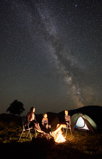 istock Family beside camp, campfire, tent under night starry sky 1128694481