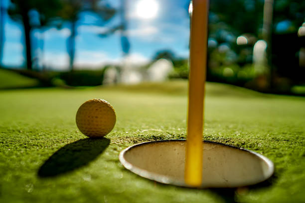 istock Mini Golf yellow ball on green grass at sunset 1128694825
