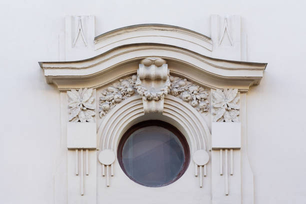 istock Round window on a white stone wall decorated with ornate stucco 1128694999