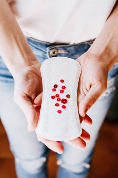 woman holding menstrual pad with red glitters, Women's health, life style stock photo