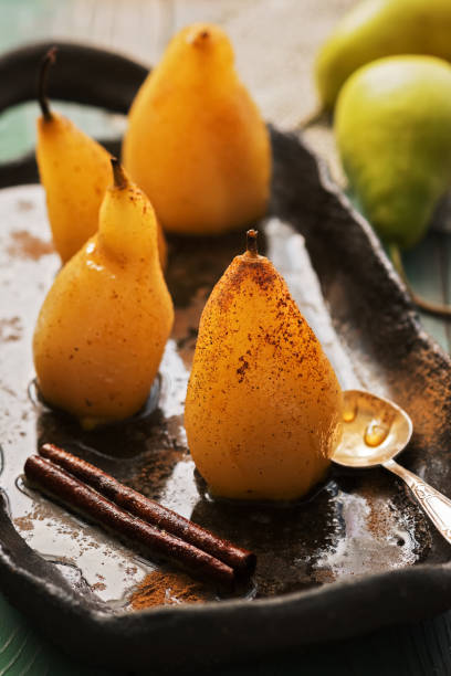 Poached pear on a rustic background.. Pear stewed in syrup, delicious winter dessert.Selective focus.