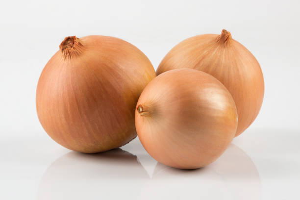 heap of fresh beige onion bulb on white background