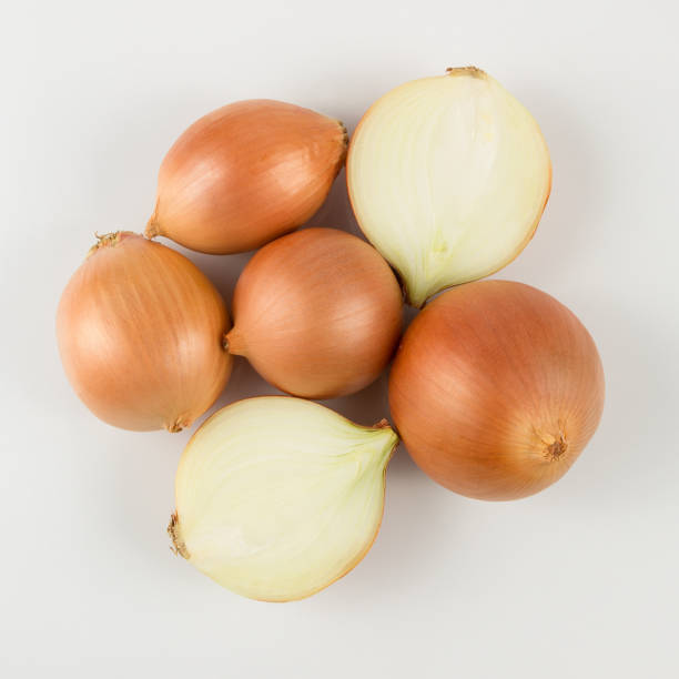 istock heap of fresh beige onion bulb on white background 1128698733