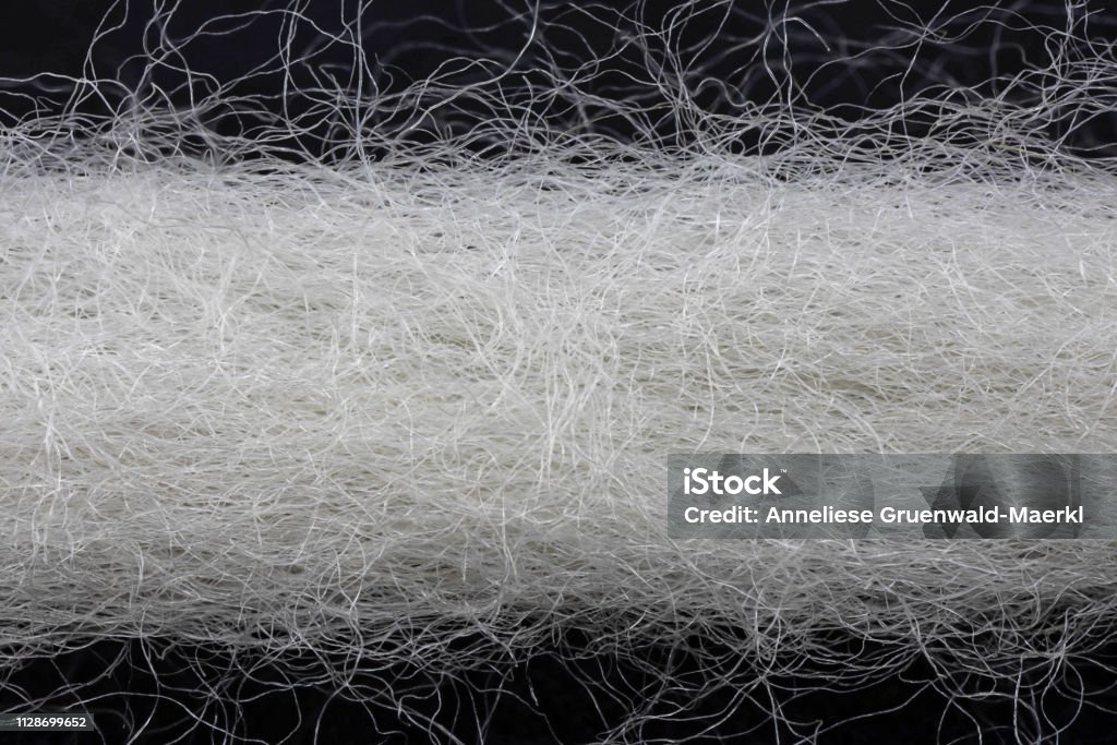 extreme close up of a wool thread white natural yarn in front of black background Fiber Stock Photo