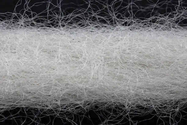 white natural yarn in front of black background