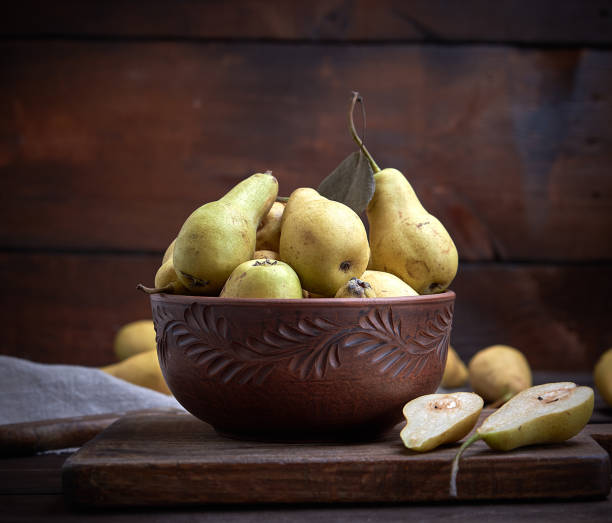 istock ripe green pears in a brown clay bowl 1128700419