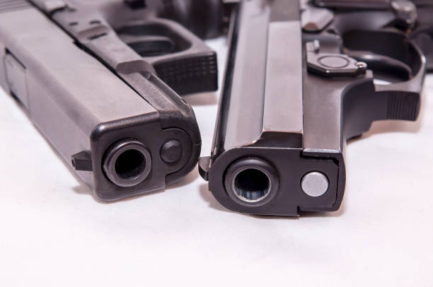 istock Two black pistols, a 40 caliber and a 9mm laying together 1128702372
