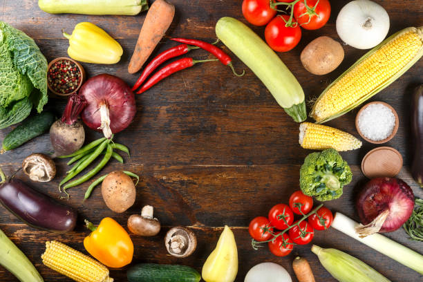 istock Summer fresh vegetables set on wooden background. 1128702654