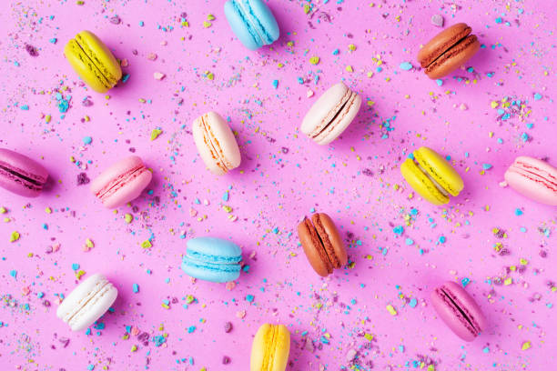 istock Colorful cake macaron or macaroon pattern on pink background top view. Flat lay. 1128702778