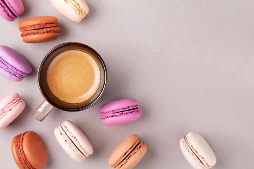 Morning cup of coffee and colorful cake macaron or macaroon top view. Flat lay style.