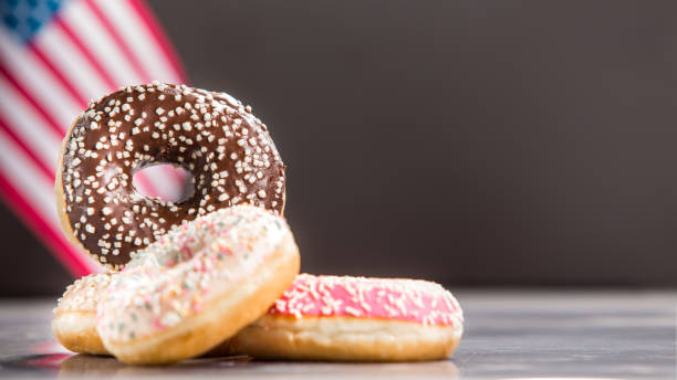 istock Various donuts and a gift over american flag. Happy holiday background 1128704976