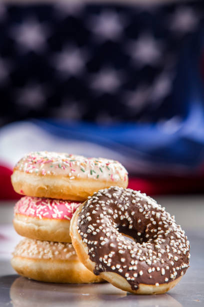 istock Various donuts and a gift over american flag. Happy holiday background 1128704977