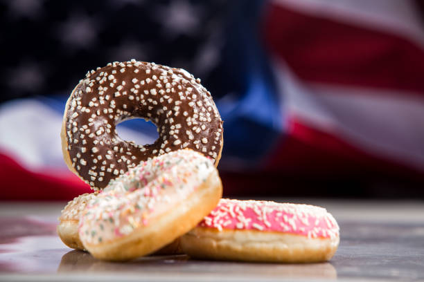 istock Various donuts and a gift over american flag. Happy holiday background 1128704978