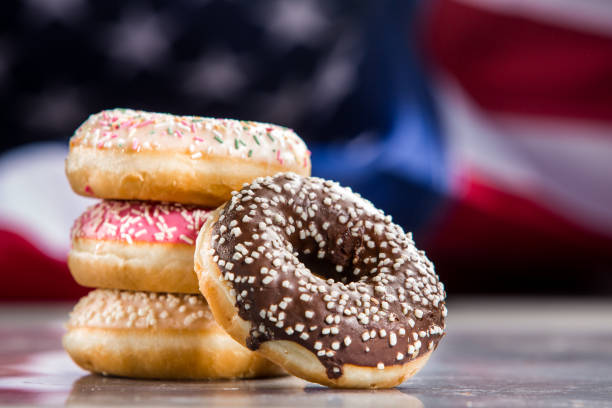 istock Various donuts and a gift over american flag. Happy holiday background 1128704980